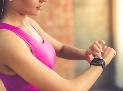 beautiful sports girl is switching on her fitbit before training