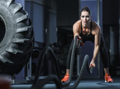 muscular woman crossfit trainer do battle workout