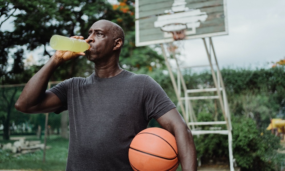 man drinking while playing basketball