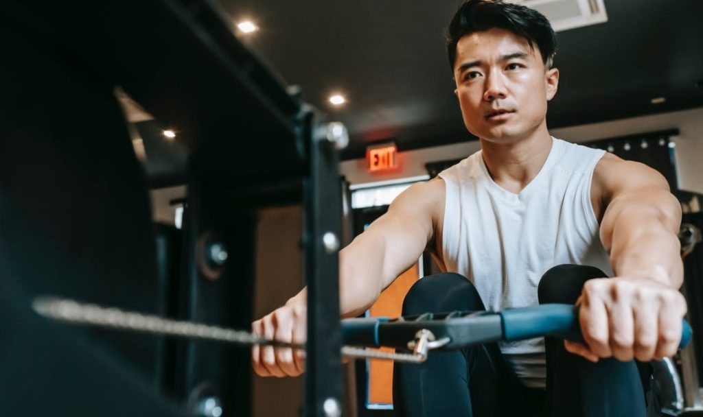 asian man rowing machine