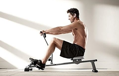 man on compact rowing machine