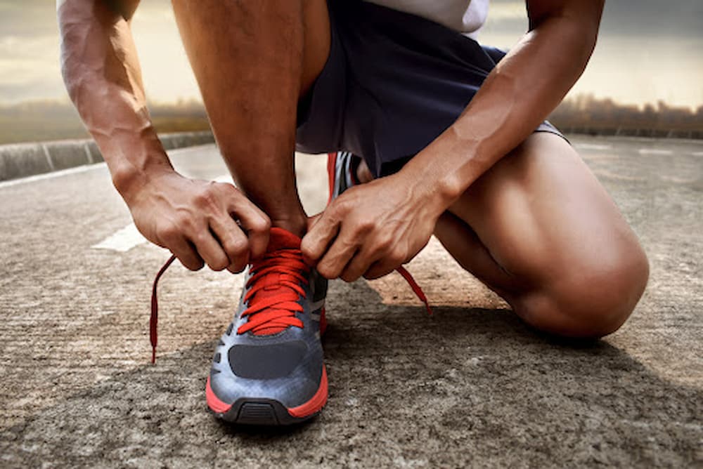 Man bending down tying running shoes