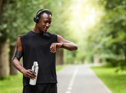 oung-fit-African-American-man-checking-sports-watch-while-out-exercising